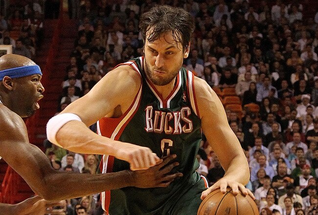MIAMI, FL - JANUARY 04:  Andrew Bogut #6 of the Milwaukee Bucks dribbles past Erick Dampier #25 of the Miami Heat during a game at American Airlines Arena on January 4, 2011 in Miami, Florida. NOTE TO USER: User expressly acknowledges and agrees that, by downloading and/or using this Photograph, User is consenting to the terms and conditions of the Getty Images License Agreement.  (Photo by Mike Ehrmann/Getty Images)