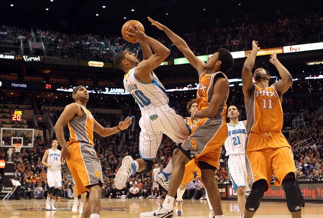 PHOENIX, AZ - DECEMBER 26:  Eric Gordon #10 of the New Orleans Hornets puts up a shot against Josh Childress #1 of the Phoenix Suns during the season openning NBA game at US Airways Center on December 26, 2011 in Phoenix, Arizona.  The Hornets defeated the Suns 85-84. NOTE TO USER: User expressly acknowledges and agrees that, by downloading and or using this photograph, User is consenting to the terms and conditions of the Getty Images License Agreement.  (Photo by Christian Petersen/Getty Images)