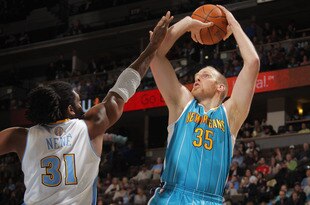 DENVER, CO - JANUARY 09:  Chris Kaman #35 of the New Orleans Hornets takes a shot over Nene Hilario #31 of the Denver Nuggets at the Pepsi Center on January 9, 2012 in Denver, Colorado. NOTE TO USER: User expressly acknowledges and agrees that, by downloading and or using this photograph, User is consenting to the terms and conditions of the Getty Images License Agreement.  (Photo by Doug Pensinger/Getty Images)