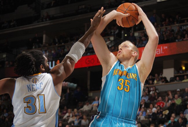 DENVER, CO - JANUARY 09:  Chris Kaman #35 of the New Orleans Hornets takes a shot over Nene Hilario #31 of the Denver Nuggets at the Pepsi Center on January 9, 2012 in Denver, Colorado. NOTE TO USER: User expressly acknowledges and agrees that, by downloading and or using this photograph, User is consenting to the terms and conditions of the Getty Images License Agreement.  (Photo by Doug Pensinger/Getty Images)