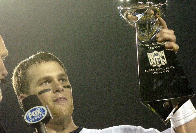 Tom Brady holds the Vince Lombardi Trophy as he stands on the podium after The New England Patriots defeated The Philadelphia Eagles in Super Bowl XXXIX at Alltel Staduim in Jacksonville, Florida. (Photo by A. Messerschmidt/Getty Images)