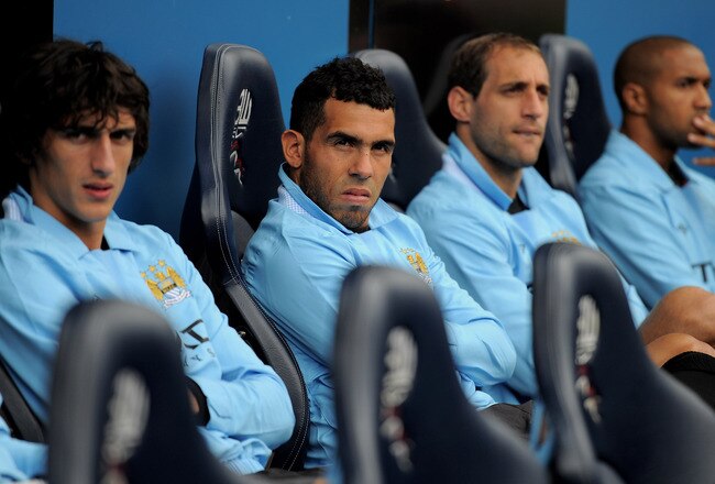 BOLTON, ENGLAND - AUGUST 21:  Carlos Tevez of Manchester City (2nd on L) watches from the bench during the Barclays Premier League match between Bolton Wanderers and Manchester City at the Reebok Stadium on August 21, 2011 in Bolton, England.  (Photo by Michael Regan/Getty Images)