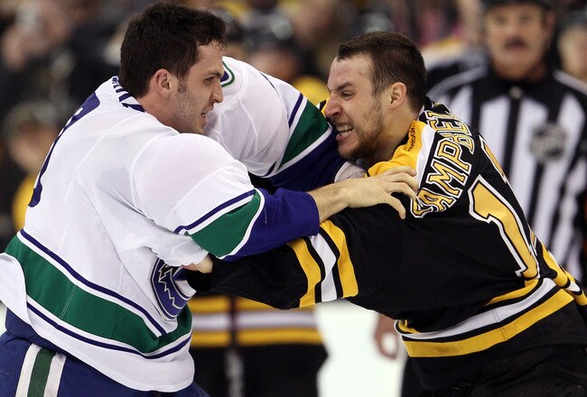 BOSTON, MA - JANUARY 07:  Maxim Lapierre #40 of the Vancouver Canucks and Gregory Campbell #11 of the Boston Bruins fight on January 7, 2012 at TD Garden in Boston, Massachusetts.  (Photo by Elsa/Getty Images)