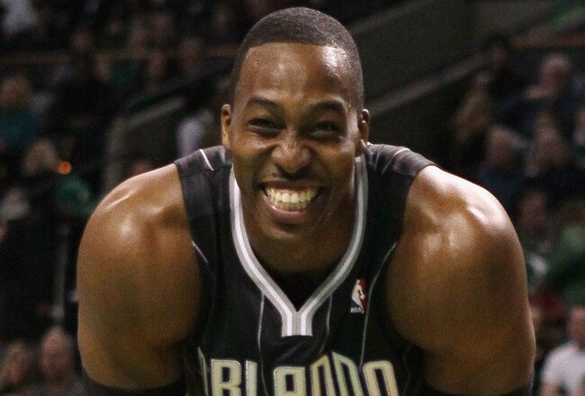BOSTON, MA - JANUARY 17:  Dwight Howard #12 of the Orlando Magic smiles on the baseline as he waits for Shaquille O'Neal of the Boston Celtics to shoot a free throw on January 17, 2011 at the TD Garden in Boston, Massachusetts.  NOTE TO USER: User expressly acknowledges and agrees that, by downloading and/or using this Photograph, User is consenting to the terms and conditions of the Getty Images License Agreement.  (Photo by Elsa/Getty Images)