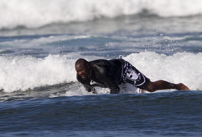 NORTH SHORE, HI - JANUARY 28:   Seven-Time Pro Bowler Warren Sapp falls off his board as he attempts to surf with the Bud Light Lime surf team on Oahu's North Shore, January 28, 2012 in Haleiwa, Hawaii.  (Photo by Marco Garcia/Getty Images for Bud Light Lime)
