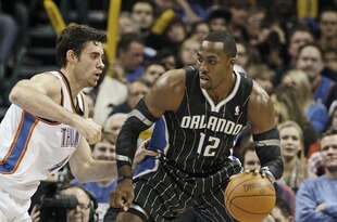 OKLAHOMA CITY, OK - DECEMBER 25:  Dwight Howard #12 of the Orlando Magic looks to drive on Nick Collison #4 of the Oklahoma City Thunder during the NBA season opening game December 25, 2011 at the Chesapeake Energy Arena in Oklahoma City, Oklahoma.  Oklahoma City defeated Orlando 97-89. NOTE TO USER: User expressly acknowledges and agrees that, by downloading and or using this Photograph, user is consenting to the terms and conditions of the Getty Images License Agreement.  (Photo by Brett Deering/Getty Images)