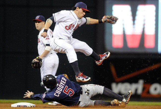CLEVELAND, OH - SEPTEMBER 23: Shortstop Asdrubal Cabrera #13 of the Cleveland Indians leaps over Michael Cuddyer #5 of the Minnesota Twins who is out at second during the sixth inning at Progressive Field on September 23, 2011 in Cleveland, Ohio. (Photo by Jason Miller/Getty Images)