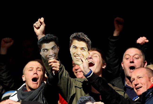 LIVERPOOL, ENGLAND - JANUARY 28:  Liverpool fans celebrate with Luis Suarez masks during the FA Cup Fourth Round match between Liverpool and Manchester United at Anfield on January 28, 2012 in Liverpool, England.  (Photo by Alex Livesey/Getty Images)