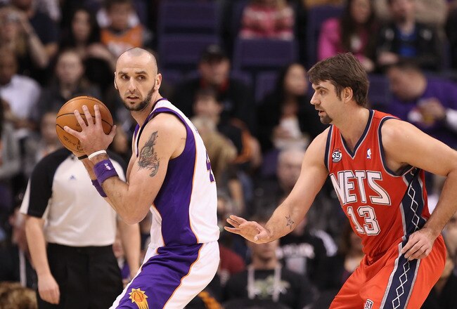 PHOENIX, AZ - JANUARY 13:  Marcin Gortat #4 of the Phoenix Suns handles the ball during the NBA game against the New Jersey Nets at US Airways Center on January 13, 2012 in Phoenix, Arizona. The Nets defeated the Suns 110-103.   NOTE TO USER: User expressly acknowledges and agrees that, by downloading and or using this photograph, User is consenting to the terms and conditions of the Getty Images License Agreement.  (Photo by Christian Petersen/Getty Images)