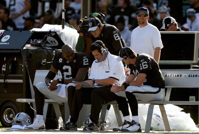 OAKLAND, CA - NOVEMBER 2:  Quarterbacks JaMarcus Russell #2, Marques Tuiasosopo #8 and Andrew Walter #16 of the Oakland Raiders watch as Offensive Coordinator Greg Knapp goes over some plays on the bench during the game against the Atlanta Falcons on November 2, 2008 at the Oakland-Alameda County Coliseum in Oakland, California. The Falcons defeated the Raiders 24-0. (Photo by Jed Jacobsohn/Getty Images)