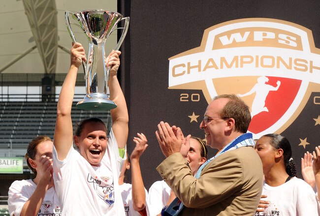 CARSON, CA - AUGUST 22:  Captain and Head Coach Christie Rampone #3 of the New Jersey Blue Sky FC hoist the trophy in front of Thomas Hofsetter, President and CEO in celebration of a 1-0 win over the Los Angeles Sol at The Home Depot Center on August 22, 2009 in Carson, California.  (Photo by Harry How/Getty Images)