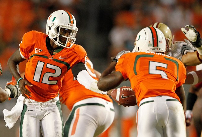 MIAMI GARDENS, FL - NOVEMBER 25:  Jacory Harris #12 of the Miami Hurricanes hands off to Mike James #5 during a game against the Boston College Eagles at Sun Life Stadium on November 25, 2011 in Miami Gardens, Florida.  (Photo by Mike Ehrmann/Getty Images)