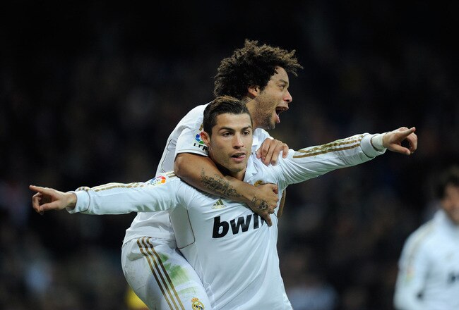MADRID, SPAIN - JANUARY 28: Cristiano Ronaldo (C) of Real Madrid celebrates with his team-mate Marcelo (L) after scoring Real's 2nd goal during the La Liga match between Real Madrid and Real Zaragoza at Estadio Santiago Bernabeu on January 28, 2012 in Madrid, Spain.  (Photo by Denis Doyle/Getty Images)
