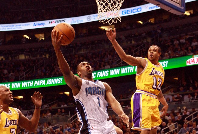 ORLANDO, FL - FEBRUARY 13:  Gilbert Arenas #1 of the Orlando Magic attempts a shot over Shannon Brown #12 of the Los Angeles Lakers during the game at Amway Arena on February 13, 2011 in Orlando, Florida.  NOTE TO USER: User expressly acknowledges and agrees that, by downloading and or using this Photograph, user is consenting to the terms and conditions of the Getty Images License Agreement.  (Photo by Sam Greenwood/Getty Images)