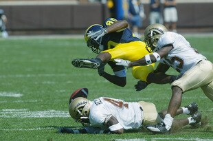 ANN ARBOR, MI - SEPTEMBER 7:  Braylon Edwards #80 of the University of Michigan Wolverines loses the ball after being hit by Sam Reynolds #41 and Scott Robinson #25 of the Western Michigan Broncos in the first half on September 7, 2002 at Michigan Stadium in Ann Arbor, Michigan.  The ball bounced out of bounds and Michigan held possesion. Michigan defeated Western Michigan 35-12.   (Photo by Danny Moloshok/Getty Images).