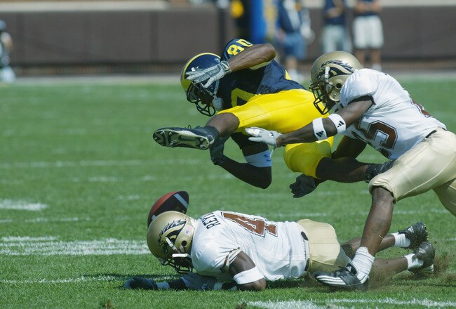 ANN ARBOR, MI - SEPTEMBER 7:  Braylon Edwards #80 of the University of Michigan Wolverines loses the ball after being hit by Sam Reynolds #41 and Scott Robinson #25 of the Western Michigan Broncos in the first half on September 7, 2002 at Michigan Stadium in Ann Arbor, Michigan.  The ball bounced out of bounds and Michigan held possesion. Michigan defeated Western Michigan 35-12.   (Photo by Danny Moloshok/Getty Images).