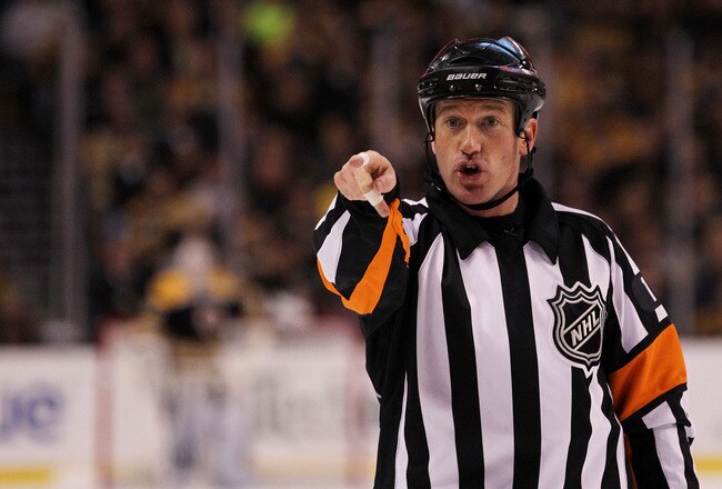 BOSTON, MA - MAY 17:  Referee Kelly Sutherland #11 makes a call in Game Two of the Eastern Conference Finals between the Boston Bruins and the Tampa Bay Lightning during the 2011 NHL Stanley Cup Playoffs at TD Garden on May 17, 2011 in Boston, Massachusetts.  (Photo by Bruce Bennett/Getty Images)