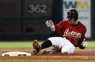 HOUSTON - SEPTEMBER 25:  Jose Altuve #27 of the Houston Astros slides into third base after a single was misplayed by centerfielder Eric Young Jr. #1 of the Colorado Rockies in the third inning at Minute Maid Park on September 25, 2011 in Houston, Texas. Colorado won 19-2.  (Photo by Bob Levey/Getty Images)