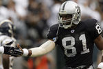 OAKLAND, CA  - SEPTEMBER 28:  Wide receiver Tim Brown #81 of the Oakland Raiders slaps a teammate's hand during a game against the San Diego Chargers on September 28, 2003 at Network Associates Coliseum in Oakland, California. The Raiders defeated the Chargers 34-31 in overtime. (Photo by Stephen Dunn/Getty Images)