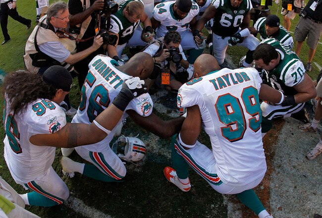 MIAMI GARDENS, FL - JANUARY 01:  Jason Taylor #99 of the Miami Dolphins prays after his final game against the New York Jets at Sun Life Stadium on January 1, 2012 in Miami Gardens, Florida.  (Photo by Mike Ehrmann/Getty Images)