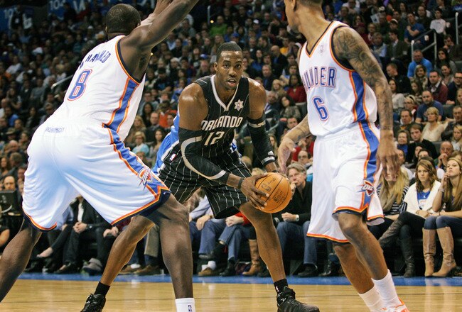 OKLAHOMA CITY, OK - DECEMBER 25:  Dwight Howard #12 of the Orlando Magic looks inside as Nazr Mohammed #8 of the Oklahoma City Thunder defends during the NBA season opening game December 25, 2011 at the Chesapeake Energy Arena in Oklahoma City, Oklahoma.  Oklahoma City led Orlando at the half. NOTE TO USER: User expressly acknowledges and agrees that, by downloading and or using this Photograph, user is consenting to the terms and conditions of the Getty Images License Agreement.  (Photo by Brett Deering/Getty Images)