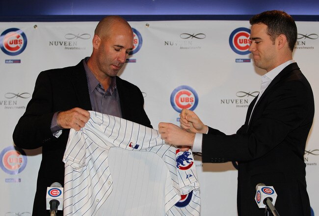CHICAGO, IL - NOVEMBER 18:  President Theo Epstein of the Chicago Cubs helps new manager Dale Sveum with his jersey during a press conference at Wrigley Field on November 18, 2011 in Chicago, Illinois.  (Photo by Jonathan Daniel/Getty Images)