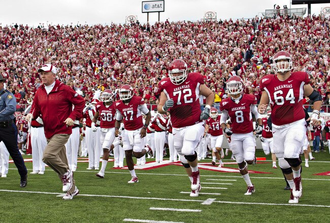 LITTLE ROCK, AR - NOVEMBER 19:   Head Coach Bobby Petrino and the Arkansas Razorbacks run onto the field before a game against the Mississippi State Bulldogs at War Memorial Stadium on November 19, 2011 in Little Rock, Arkansas. The Razorbacks defeated the Bulldogs 44-17.  (Photo by Wesley Hitt/Getty Images)
