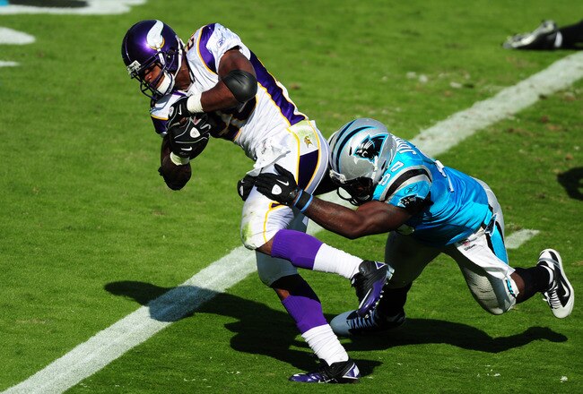 CHARLOTTE, NC - OCTOBER 30: Adrian Peterson #28 of the Minnesota Vikings scores a touchdown against Charles Johnson #95 of the Carolina Panthers at Bank of America Stadium on October 30, 2011 in Charlotte, North Carolina. (Photo by Scott Cunningham/Getty Images)
