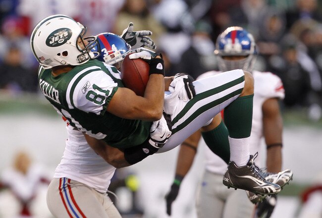 EAST RUTHERFORD, NJ - DECEMBER 24:  Dustin Keller #81 of the New York Jets makes a catch and is lifted and tackled by Deon Grant #34 of the New York Giants during the third quarter at MetLife Stadium on December 24, 2011 in East Rutherford. New Jersey. (Photo by Rich Schultz /Getty Images)