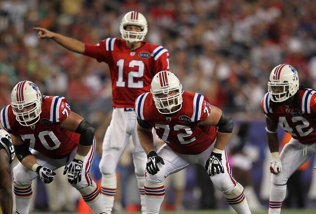 FOXBORO, MA - OCTOBER 9:   Tom Brady #12 of the New England Patriots with the help of  Matt Light #72 of the New England Patriots lead the offense during a game against the New York Jets at Gillette Stadium on October 9, 2011 in Foxboro, Massachusetts. The Patriots won 30-21. (Photo by Jim Rogash/Getty Images)