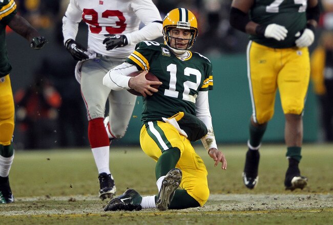 GREEN BAY, WI - JANUARY 15:   Aaron Rodgers #12 of the Green Bay Packers slides with the ball after a run against the New York Giants during their NFC Divisional playoff game at Lambeau Field on January 15, 2012 in Green Bay, Wisconsin.  (Photo by Jamie Squire/Getty Images)