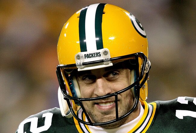 GREEN BAY, WI - DECEMBER 25:  Quarterback Aaron Rodgers #12 of the Green Bay Packers smiles as he leaves the field after a touchdown in the fourth quarter against the Chicago Bears at Lambeau Field on December 25, 2011 in Green Bay, Wisconsin.  (Photo by Matthew Stockman/Getty Images)