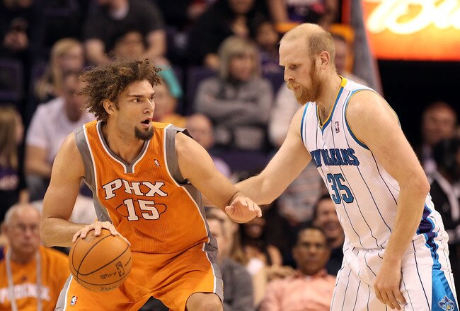 PHOENIX, AZ - DECEMBER 26:  Robin Lopez #15 of the Phoenix Suns handles the ball under pressure from Chris Kaman #35 of the New Orleans Hornets during the season openning NBA game at US Airways Center on December 26, 2011 in Phoenix, Arizona. The Hornets defeated the Suns 85-84. NOTE TO USER: User expressly acknowledges and agrees that, by downloading and or using this photograph, User is consenting to the terms and conditions of the Getty Images License Agreement.  (Photo by Christian Petersen/Getty Images)