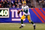EAST RUTHERFORD, NJ - DECEMBER 04:  Aaron Rodgers #12 of the Green Bay Packers rolls out of the pocket and looks to pass in the second half against the New York Giants at MetLife Stadium on December 4, 2011 in East Rutherford, New Jersey.  (Photo by Chris Trotman/Getty Images)