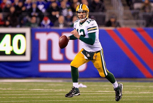 EAST RUTHERFORD, NJ - DECEMBER 04:  Aaron Rodgers #12 of the Green Bay Packers rolls out of the pocket and looks to pass in the second half against the New York Giants at MetLife Stadium on December 4, 2011 in East Rutherford, New Jersey.  (Photo by Chris Trotman/Getty Images)
