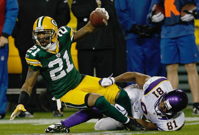GREEN BAY, WI - NOVEMBER 14: Charles Woodson #21 of the Green Bay Packers intercepts the football as he is tackled by Devin Aromashadu #19 of the Minnesota Vikings at Lambeau Field on November 14, 2011 in Green Bay, Wisconsin. (Photo by Scott Boehm/Getty Images)