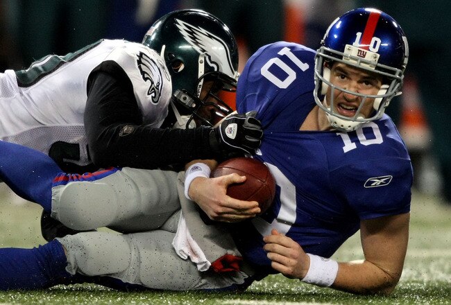 EAST RUTHERFORD, NJ - DECEMBER 13:  Eli Manning #10 of the New York Giants gets sacked late in the game by Will Witherspoon #50 of the Philadelphia Eagles at Giants Stadium on December 13, 2009 in East Rutherford, New Jersey.  (Photo by Nick Laham/Getty Images)