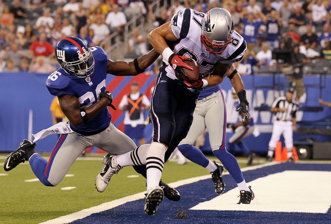 EAST RUTHERFORD, NJ - SEPTEMBER 02:  Rob Gronkowski #87 of the New England Patriots carries a reception into the endzone past Antrel Rolle #26 of the New York Giants for a first quarter touchdown on September 2, 2010 at the New Meadowlands Stadium in East Rutherford, New Jersey.  (Photo by Jim McIsaac/Getty Images)