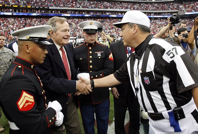 HOUSTON - NOVEMBER 06:  Former U.S. President George H. W. Bush shakes hands with referee Alberto Riveron #57 before the coin toss as the Cleveland Browns play the Houston Texans at Reliant Stadium on November 6, 2011 in Houston, Texas.  (Photo by Bob Levey/Getty Images)
