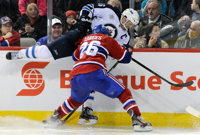 MONTREAL, CANADA - FEBRUARY 5:  Josh Gorges #26 of the Montreal Canadiens body checks Andrew Ladd #16 of the Winnipeg Jets during the NHL game at the Bell Centre on February 5, 2012 in Montreal, Quebec, Canada.  The Canadiens defeated the Jets 3-0.  (Photo by Richard Wolowicz/Getty Images)