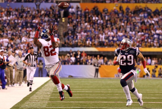 INDIANAPOLIS, IN - FEBRUARY 05:  Mario Manningham #82 of the New York Giants makes a catch out of bounds over Sterling Moore #29 of the New England Patriots in the fourth quarter during Super Bowl XLVI at Lucas Oil Stadium on February 5, 2012 in Indianapolis, Indiana.  (Photo by Al Bello/Getty Images)