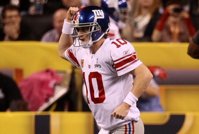 INDIANAPOLIS, IN - FEBRUARY 05:  Quarterback Eli Manning #10 of the New York Giants celebrates after his first quarter touchdown pass to Victor Cruz #80 against the New England Patriots during Super Bowl XLVI at Lucas Oil Stadium on February 5, 2012 in Indianapolis, Indiana. Manning, named MVP, led the Giants to a 21-17 victory.  (Photo by Win McNamee/Getty Images)
