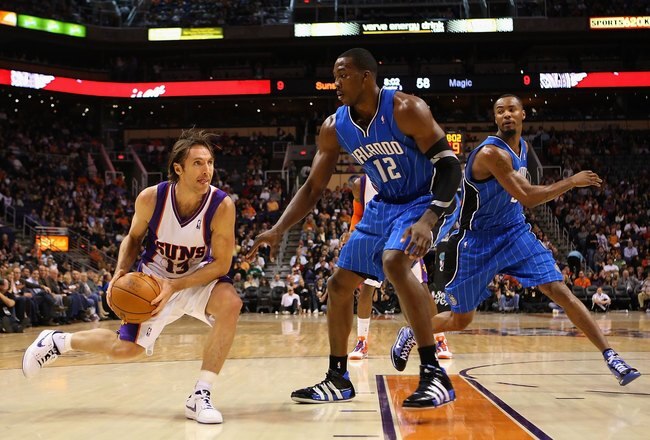 PHOENIX - DECEMBER 11:  Steve Nash #13 of the Phoenix Suns handles the ball under pessure from Dwight Howard #12 of the Orlando Magic during the NBA game at US Airways Center on December 11, 2009 in Phoenix, Arizona. The Suns defeated the Magic 106-103.  NOTE TO USER: User expressly acknowledges and agrees that, by downloading and or using this photograph, User is consenting to the terms and conditions of the Getty Images License Agreement.  (Photo by Christian Petersen/Getty Images)