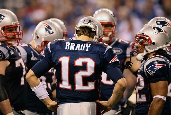 INDIANAPOLIS, IN - FEBRUARY 05:  Quarterback Tom Brady #12 of the New England Patriots waits with his offense in the huddle during the third quarter against the New York Giants during Super Bowl XLVI at Lucas Oil Stadium on February 5, 2012 in Indianapolis, Indiana.  (Photo by Ezra Shaw/Getty Images)