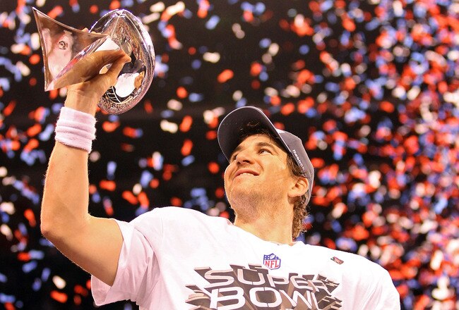 INDIANAPOLIS, IN - FEBRUARY 05:  Quarterback Eli Manning #10 of the New York Giants poses with the Vince Lombardi Trophy after the Giants defeated the Patriots by a score of 21-17 in Super Bowl XLVI at Lucas Oil Stadium on February 5, 2012 in Indianapolis, Indiana.  (Photo by Ezra Shaw/Getty Images)