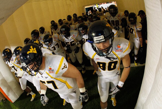 MIAMI GARDENS, FL - JANUARY 04:  Jeff Braun #57 and Ryan Nehlen #80 of the West Virginia Mountaineers run out of the tunnel onto the field against the Clemson Tigers during the Discover Orange Bowl at Sun Life Stadium on January 4, 2012 in Miami Gardens, Florida.  (Photo by Mike Ehrmann/Getty Images)