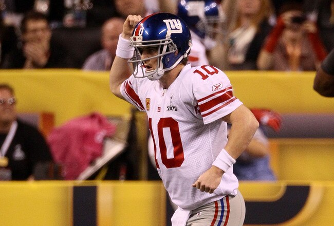 INDIANAPOLIS, IN - FEBRUARY 05:  Quarterback Eli Manning #10 of the New York Giants celebrates after his first quarter touchdown pass to Victor Cruz #80 against the New England Patriots during Super Bowl XLVI at Lucas Oil Stadium on February 5, 2012 in Indianapolis, Indiana. Manning, named MVP, led the Giants to a 21-17 victory.  (Photo by Win McNamee/Getty Images)
