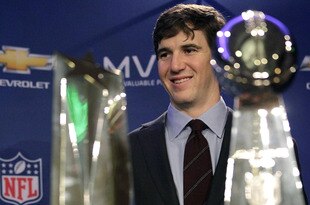 INDIANAPOLIS, IN - FEBRUARY 06:  In this General Motors handout, Eli Manning #10 of the New York Giants poses with the Super Bowl Championship Lombardi Trophy (right) and the Pete Rozelle Trophy for being the Super Bowl XLVI Most Valuable Player after defeating the New England Patriots during Super Bowl XLVI on February 6, 2012 in Indianapolis, Indiana. Manning, named MVP, led the Giants to a 21-17 victory.  (Photo by AJ Mast/General Motors via Getty Images)