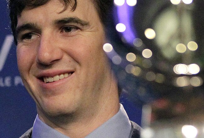 INDIANAPOLIS, IN - FEBRUARY 06:  In this General Motors handout, Eli Manning #10 of the New York Giants poses with the Super Bowl Championship Lombardi Trophy (right) and the Pete Rozelle Trophy for being the Super Bowl XLVI Most Valuable Player after defeating the New England Patriots during Super Bowl XLVI on February 6, 2012 in Indianapolis, Indiana. Manning, named MVP, led the Giants to a 21-17 victory.  (Photo by AJ Mast/General Motors via Getty Images)