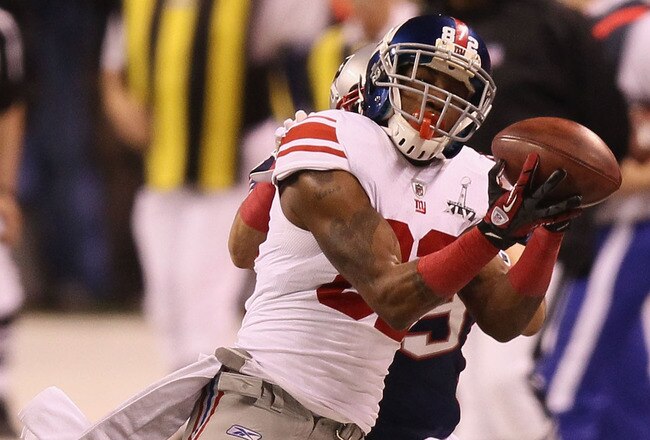 INDIANAPOLIS, IN - FEBRUARY 05:  Mario Manningham #82 of the New York Giants makes a catch on the sidelines against Sterling Moore #29 of the New England Patriots for a gain of 39 yards in the fourth quarter during Super Bowl XLVI at Lucas Oil Stadium on February 5, 2012 in Indianapolis, Indiana.  (Photo by Win McNamee/Getty Images)
